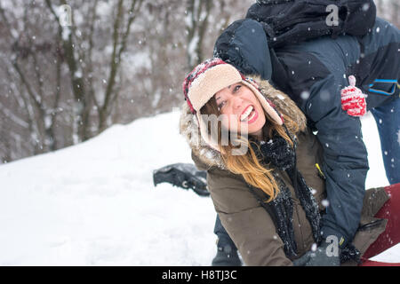 Verrückte Paare, die Spaß im Schnee bedeckt park Stockfoto