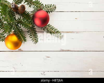 Weihnachten Hintergrund mit Tannengrün und Weihnachtskugeln auf weiß lackiertem Holz Stockfoto