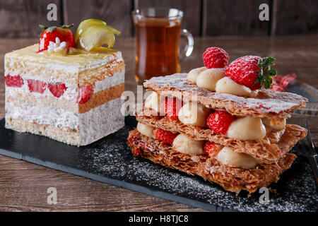 Sahnetorte Erdbeer Glasur Mille Feuille Dessert süß auf schwarzem Stein Stockfoto