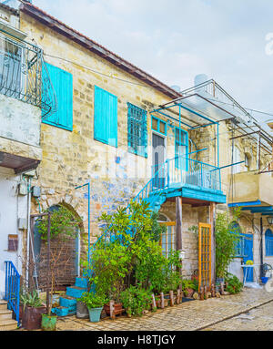 Das Steinhaus dekoriert mit leuchtend blauen Fensterläden und viele Pflanzen in Töpfen, Safed, Israel. Stockfoto