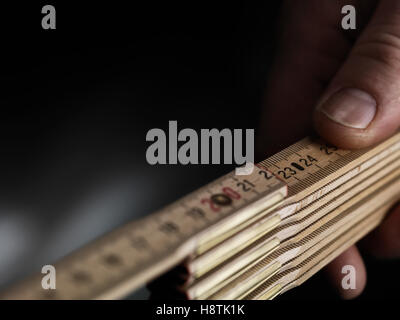 Nahaufnahme aus Holz Zollstock mit einer hand Stockfoto