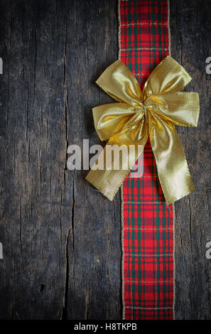 Weihnachten Ribbon und goldenen Geschenk Bogen auf alten hölzernen Hintergrund isoliert Stockfoto