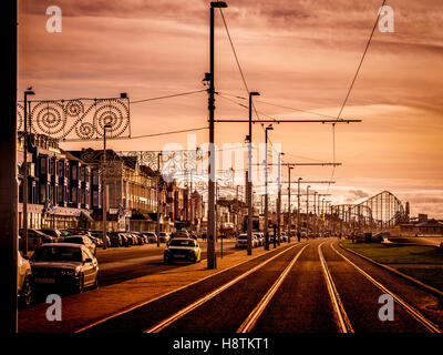 Straßenbahnschienen entlang der Strandpromenade in Blackpool, Lancashire, UK, mit Vergnügen Strand Big Dipper in Ferne. Stockfoto