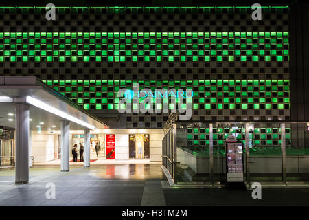Japan, Osaka Station Stadt. South Gate Gebäude mit Eingang Daimaru Kaufhaus und beleuchtete Wand mit Store Logo und Namen. Nacht. Stockfoto