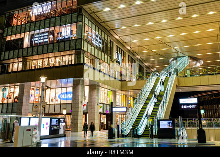 Japan, Osaka Station Stadt Interieur. North Gate Gebäude Eingangsbereich mit Lucua store, Treppen und Rolltreppen auf die nächste Ebene. Nacht. Menschen. Stockfoto