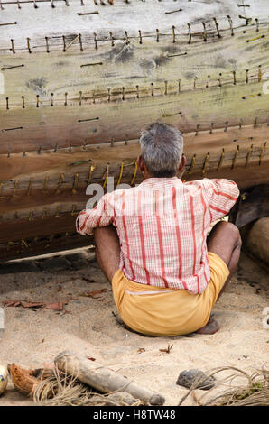 Ein Mann, die Festsetzung eines Fischerbootes, Varkala, Kerala, Südindien Stockfoto