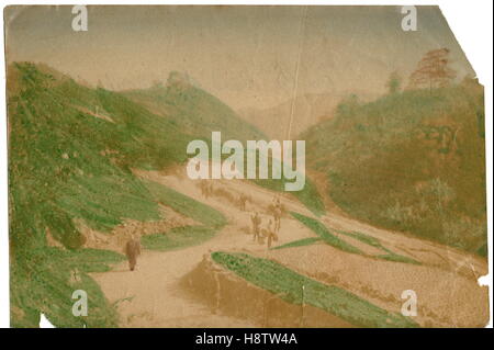 AJAXNETPHOTO. 1900-1905 (CA.). MOGI, JAPAN. -MENSCHEN ZU FUß ENTLANG A ZU VERFOLGEN, IN EINER HÜGELIGEN REGION ABGEBILDET IN EINEM ANFANG DES 20. JAHRHUNDERTS HAND FARBIGEN UND SCHWARZ EIWEISS DRUCKEN FOTOGRAF: UNBEKANNT © DIGITAL BILD COPYRIGHT AJAX VINTAGE BIBLIOTHEK BILDQUELLE: AJAX VINTAGE BILDBIBLIOTHEK SAMMLUNG REF: 161408 34 Stockfoto