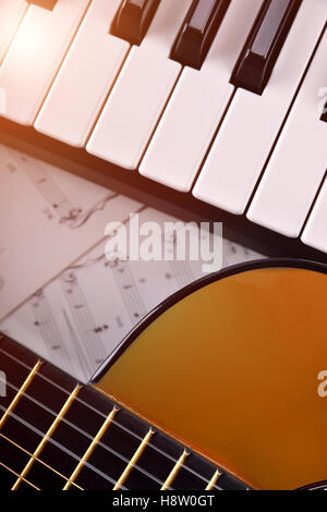 Klavier und Gitarre mit Glanz und Noten Hintergrund. Vertikale Zusammensetzung. Ansicht von oben Stockfoto