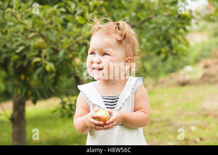 Babymädchen unter dem Apfelbaum Stockfoto