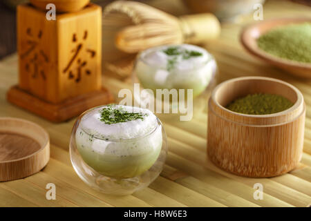 Glas von Matcha-grünen Tee-Latte auf Bambus-Tablett Stockfoto