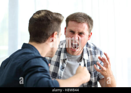 Zwei böse Freunde oder Mitbewohner streiten und droht in das Wohnzimmer zu Hause Stockfoto