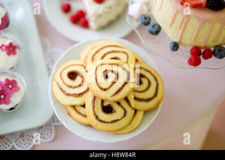 Spiral-Kekse, Kuchen und Muffins auf Tisch gelegt. Stockfoto