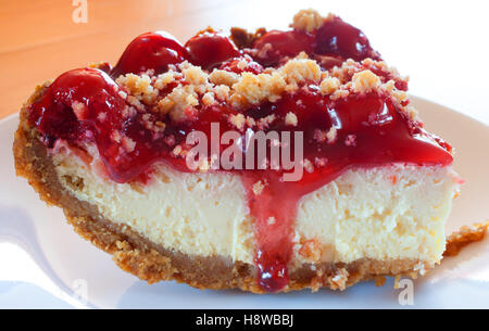 Großes Stück Käsekuchen mit Keks Kruste und Kirsch-topping Stockfoto