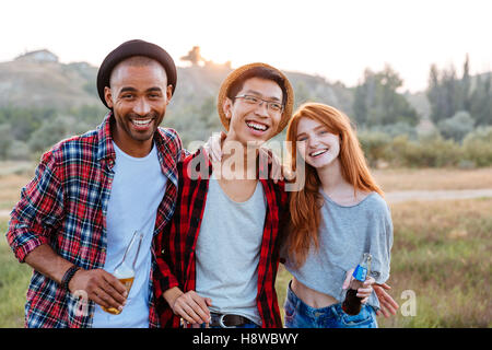 Porträt von lächelnden jungen Menschen stehen und umarmt zusammen im freien Stockfoto