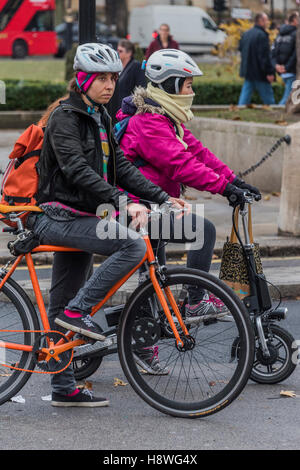 Eine weibliche Pendler auf Elektro Faltrad. Touristen und Pendler in Parliament Square, London, UK. Stockfoto
