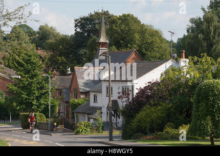 Eine Ferne Radfahrer Fahrrad durch das Dorf Snitterfield, Warwickshire, England, UK Stockfoto