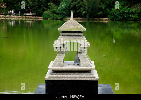 Eine kleine buddhistische Glocke befindet sich in einer überdachten Pagode auf einem grünen Teich auf der Insel Putuoshan liegt in der Provinz Zhejiang Stockfoto