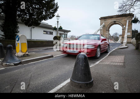 Ein rotes Auto fährt über die einzige Hängebrücke über die nicht-Gezeiten Themse Marlow. Es wurde von William Tierney Clark entworfen. Stockfoto