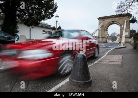 Ein rotes Auto fährt über die einzige Hängebrücke über die nicht-Gezeiten Themse Marlow. Es wurde von William Tierney Clark entworfen. Stockfoto