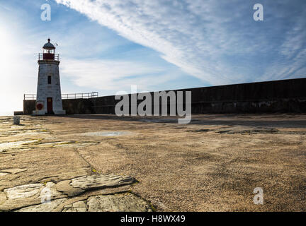 Lybster Hafen Leuchtturm mit der Sonne im Rücken neben der Hafenmauer. Stockfoto