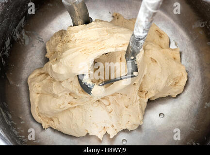 Blick von oben in einen großen industriellen Mixer in einer Bäckerei schlagen eine Last von frischem rohen Teig für Gebäck Stockfoto