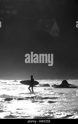 Surfer aus den Wellen bei Sables Blancs Strand Locquirec, Frankreich Stockfoto