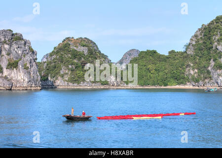 Vietnamesische Fischer unter Kajaks für Touristen in Halong Bucht, Vietnam, Indochina, Asien Stockfoto