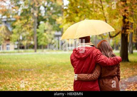 Brautpaar mit Regenschirm Wandern im herbstlichen park Stockfoto
