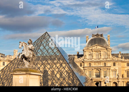 PARIS - 19. September 2013: Equestrian Statue von König Louis XIV vor Louvre-Palast und die Pyramide in Paris, Frankreich. Stockfoto