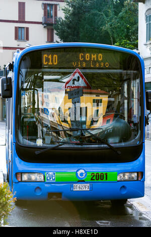 Dorfbus in Argegno. Comer See Italien. Dorf-Gebäude und Schilder in Windschutzscheibe reflektiert. Stockfoto