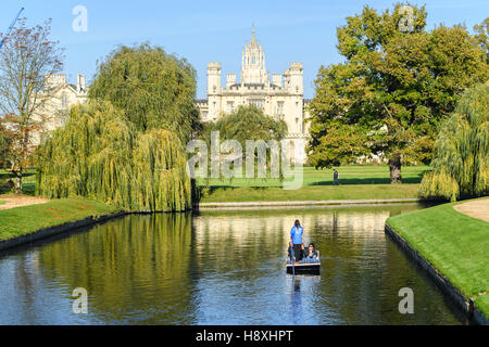 Stechkahn fahren entlang des Flusses Cam in den Gärten des Trinity College, Universität Cambridge, England, mit St John's College im Hintergrund.