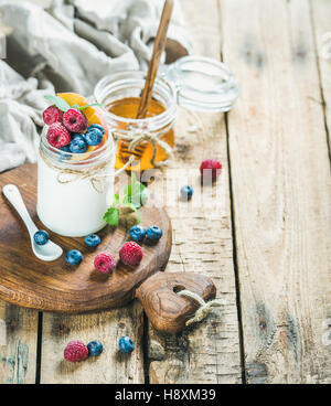 Weiße Joghurt im Glas mit frischen Beeren, Minze und Honig Stockfoto