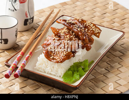 Teriyaki Huhn mit Reis auf einer rechteckigen Platte serviert. Stockfoto