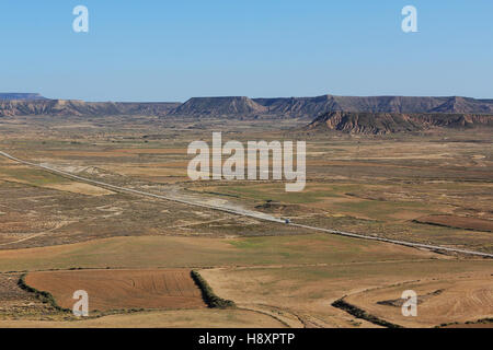 BARDENAS REALES, NAVARRA/Spanien - 16. August 2014: Ein Auto fährt auf einem Schotterweg durch Bardenas Reales Naturpark. Stockfoto