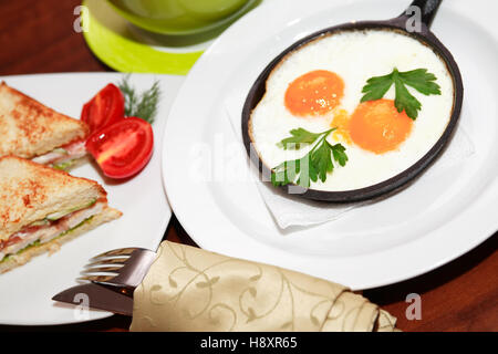 Satz von Frühstück am Tisch. Spiegeleier. Trinksprüche. Tomaten Stockfoto