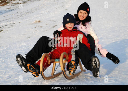 Mutter und Sohn Rodeln Stockfoto