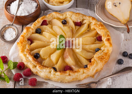 Traditionelle hausgemachte Kuchen mit Früchten und Sahne. Zubereitet mit frischen Birnen, Himbeeren und Preiselbeeren. Stockfoto