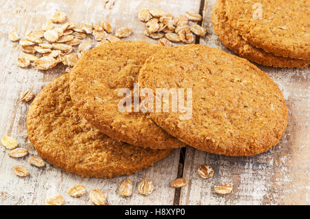 Hafer-Kekse mit Hafer auf einem weißen Holztisch. Stockfoto