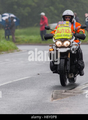 Ein Rennen Marschall Unterstützung der Radfahrer im Wettbewerb mit der Tour of Britain Radrennen Kendal in Cumbria Eintritt in Stockfoto