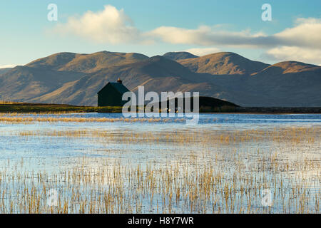 Hütte und man auf Urlar Moor, über Kenmore, Perthshire, Schottland.  Carn Mairg über Glen Lyon im Hintergrund. Stockfoto