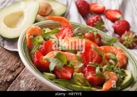 Sommer-Salat mit Erdbeeren, Avocado, Garnelen und Rucola Nahaufnahme auf einer Platte. horizontale Stockfoto