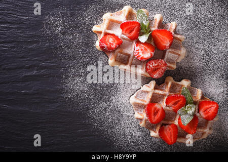 Lütticher Waffeln mit frischen Erdbeeren, Puderzucker Nahaufnahme auf der Schiefertafel. Horizontale Ansicht von oben Stockfoto