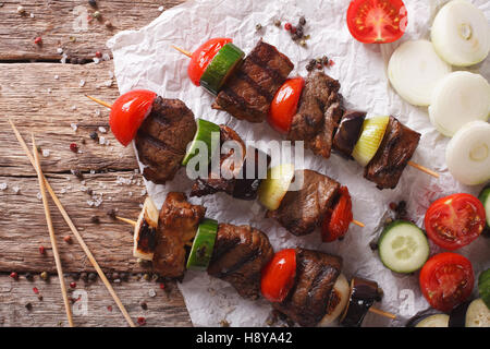 Schaschlik am Spieß mit Gemüse-close-up auf dem Tisch. horizontale Ansicht von oben Stockfoto