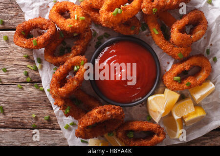 Tintenfischringe paniert in Paniermehl und Tomaten Sauce Closeup auf einem Tisch. Horizontale Ansicht von oben Stockfoto