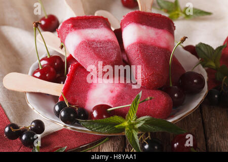 Hausgemachte Eis am Stiel mit Minze und Kirsche auf eine Stick-Nahaufnahme auf dem Tisch. horizontale Stockfoto
