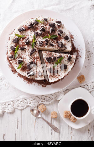 Lecker Käsekuchen mit Schokolade Cookies Closeup auf einem Teller. Vertikale Ansicht von oben Stockfoto