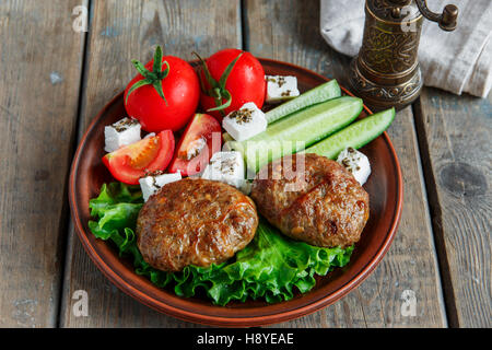 gebratene Schnitzel im Teller mit Gemüse auf Holztisch, auf einen Teller legen Stockfoto