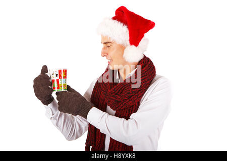 Hübscher junger Mann in Schal und Nikolausmütze, Weihnachten Tasse Stockfoto