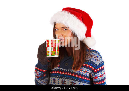 Schönes junges Mädchen trägt Pullover, Handschuhe und Weihnachtsmann Hut, hält weihnachtsbecher, Blick auf die Kamera Stockfoto