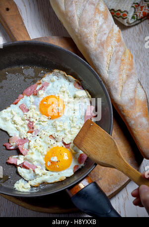 Spiegeleier in einer Pfanne erhitzen und hausgemachtem Brot Stockfoto